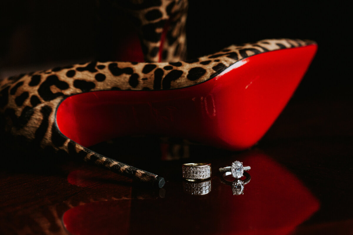 Bridal shoes and wedding rings on table