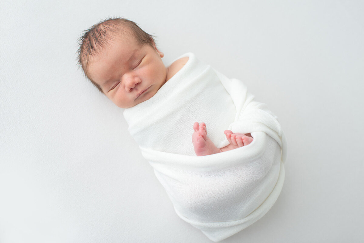 newborn baby wrapped in white