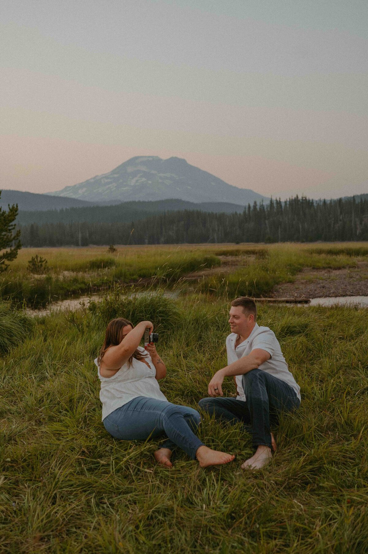 couple sitting in a meadow near sparks lake