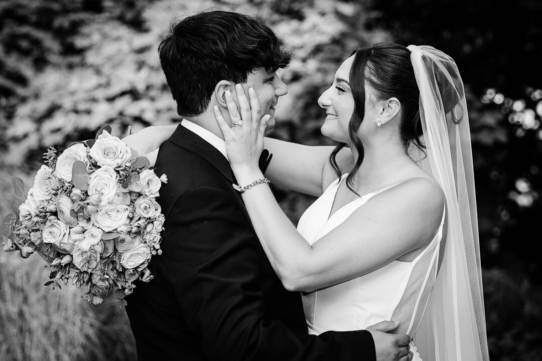Black and white photo of bride and groom kissing during their New Jersey wedding ceremony.