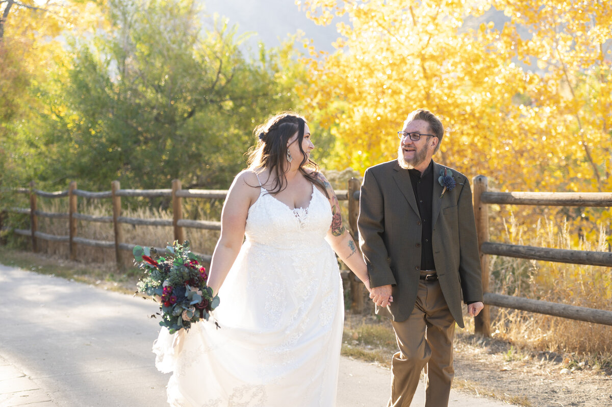 Newlyweds walking by the Golden Hotel along the fence line late October