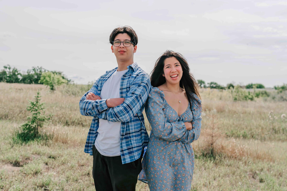 2 older siblings standing shoulder to shoulder. 