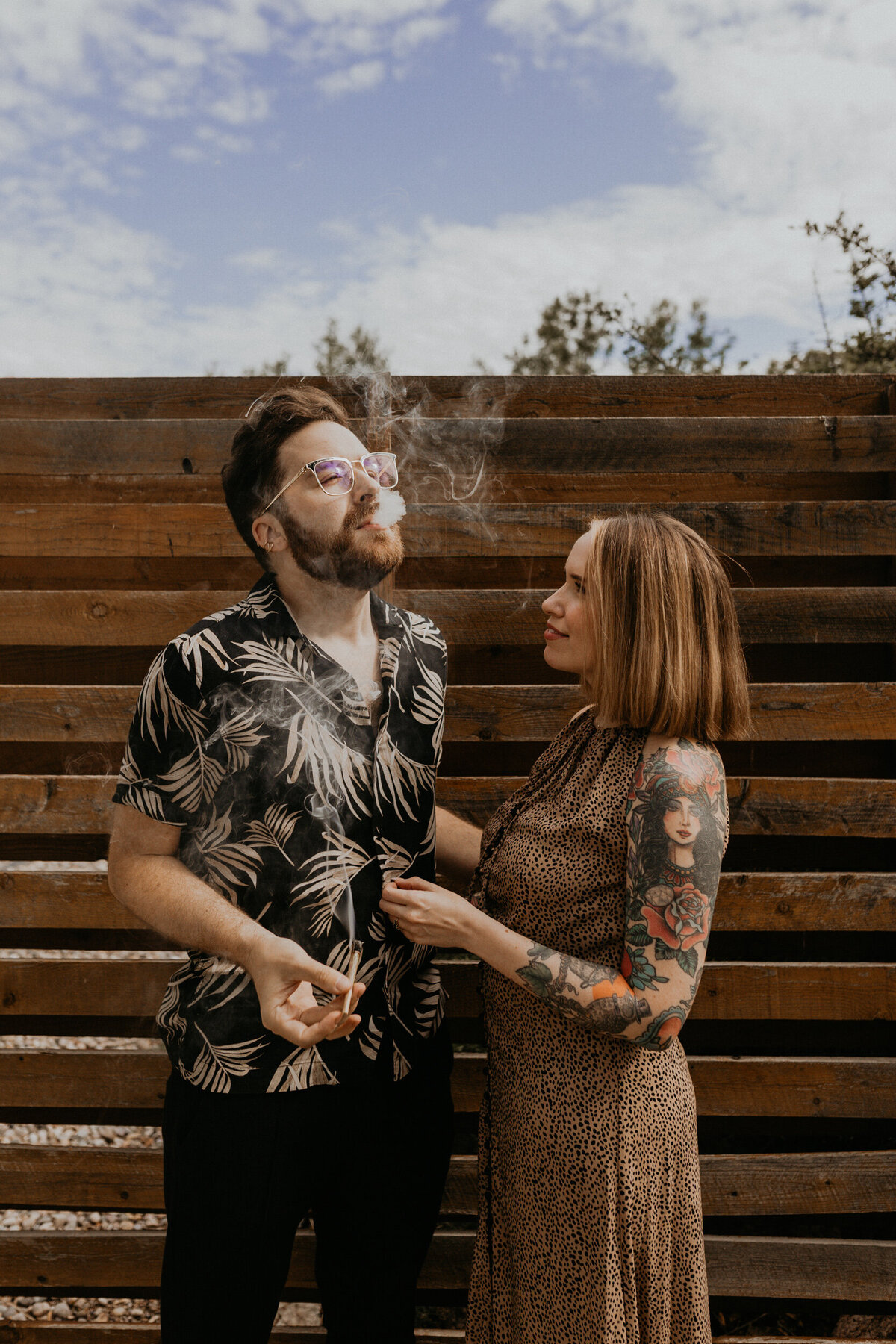 engaged couple smoking weed on porch together laughing