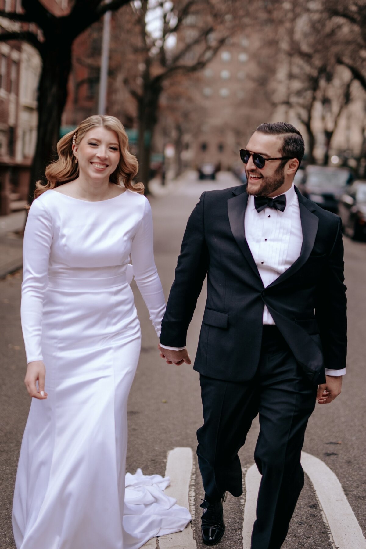 Bride and Groom holding hands walking down a street in NYC just after saying I Do.