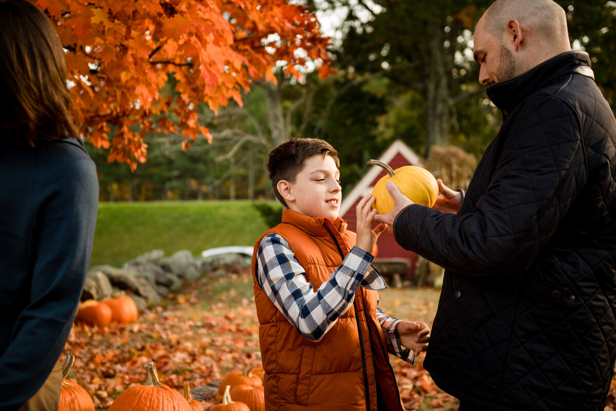 son looking at pumpkin