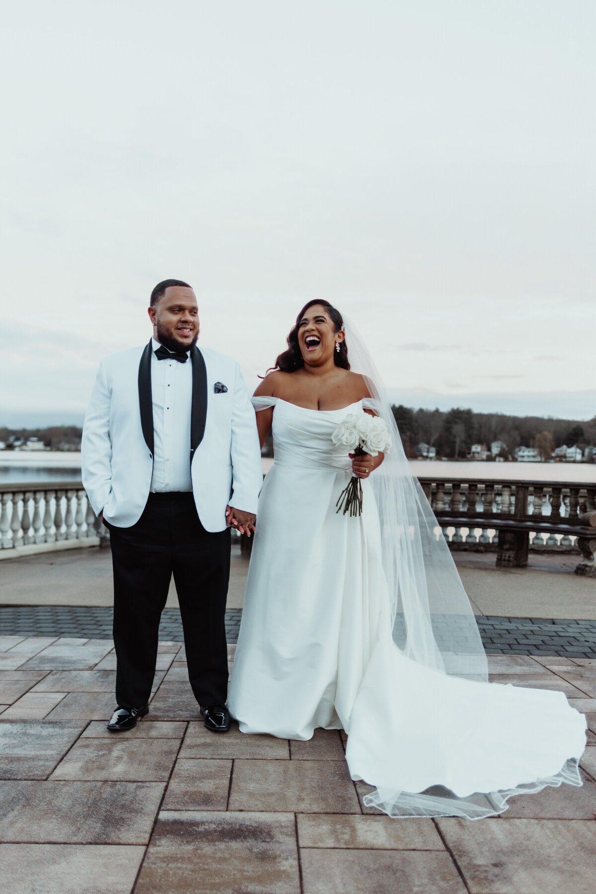 Bride and groom stnading side by side laughing