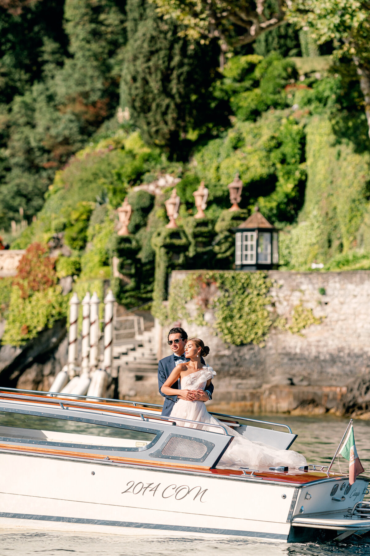 Couple on board a private board for lake como elopement by white orchid photography