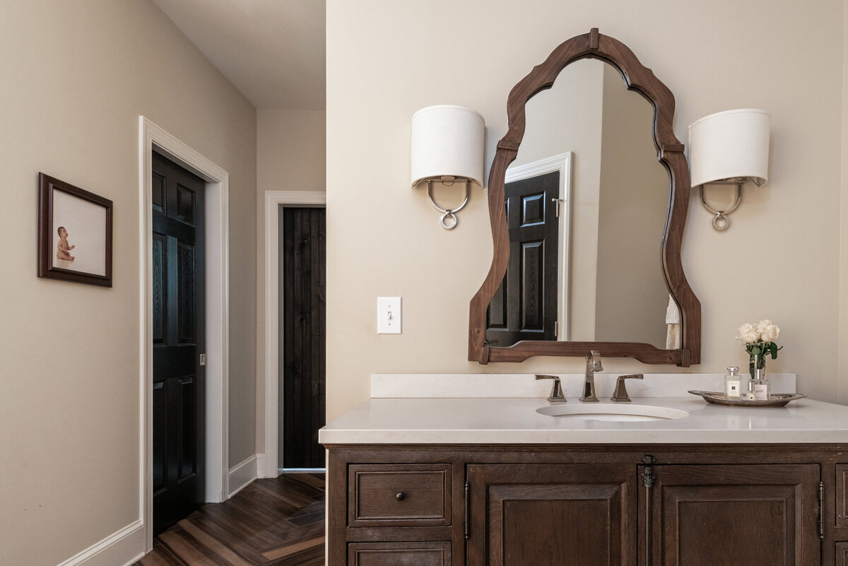 Sophisticated bathroom in Lake Norman, NC, with a dark wood vanity, elegant sconces, and warm tones.