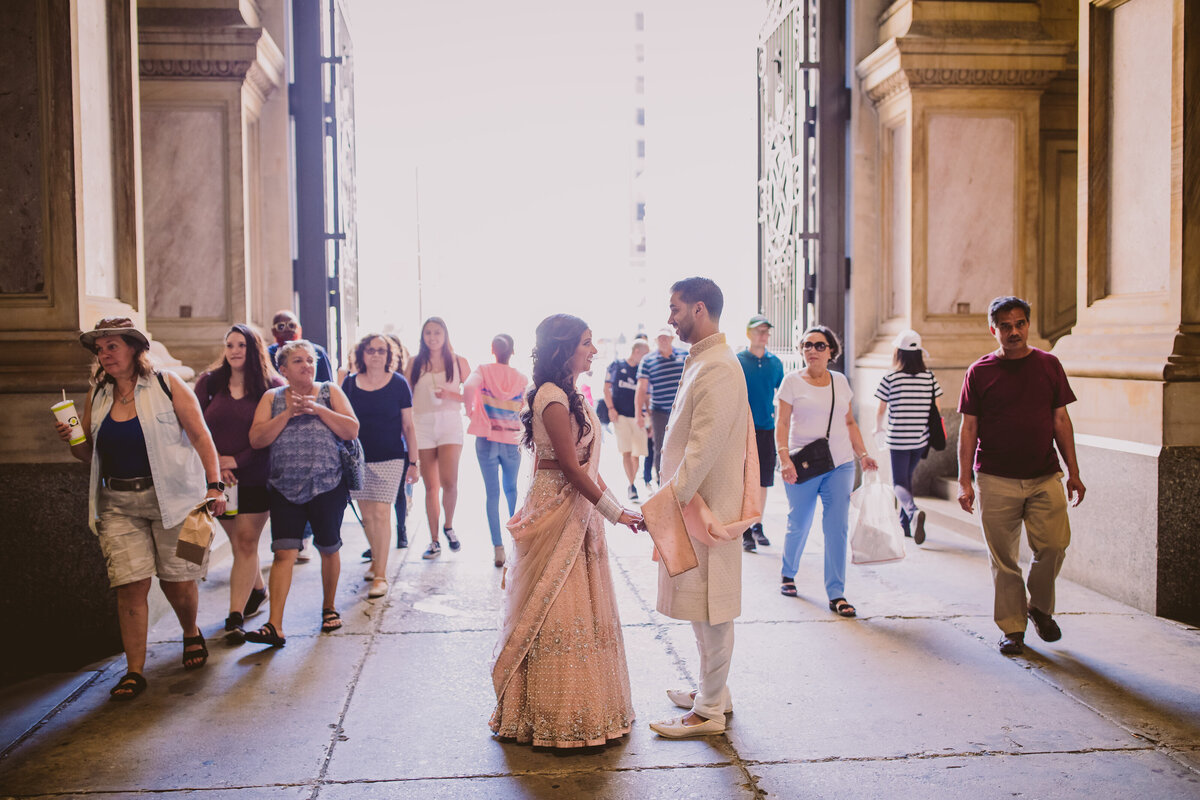 An indian bride and groom have their first look on the wedding day with many onlookers at the philadelphia city hall