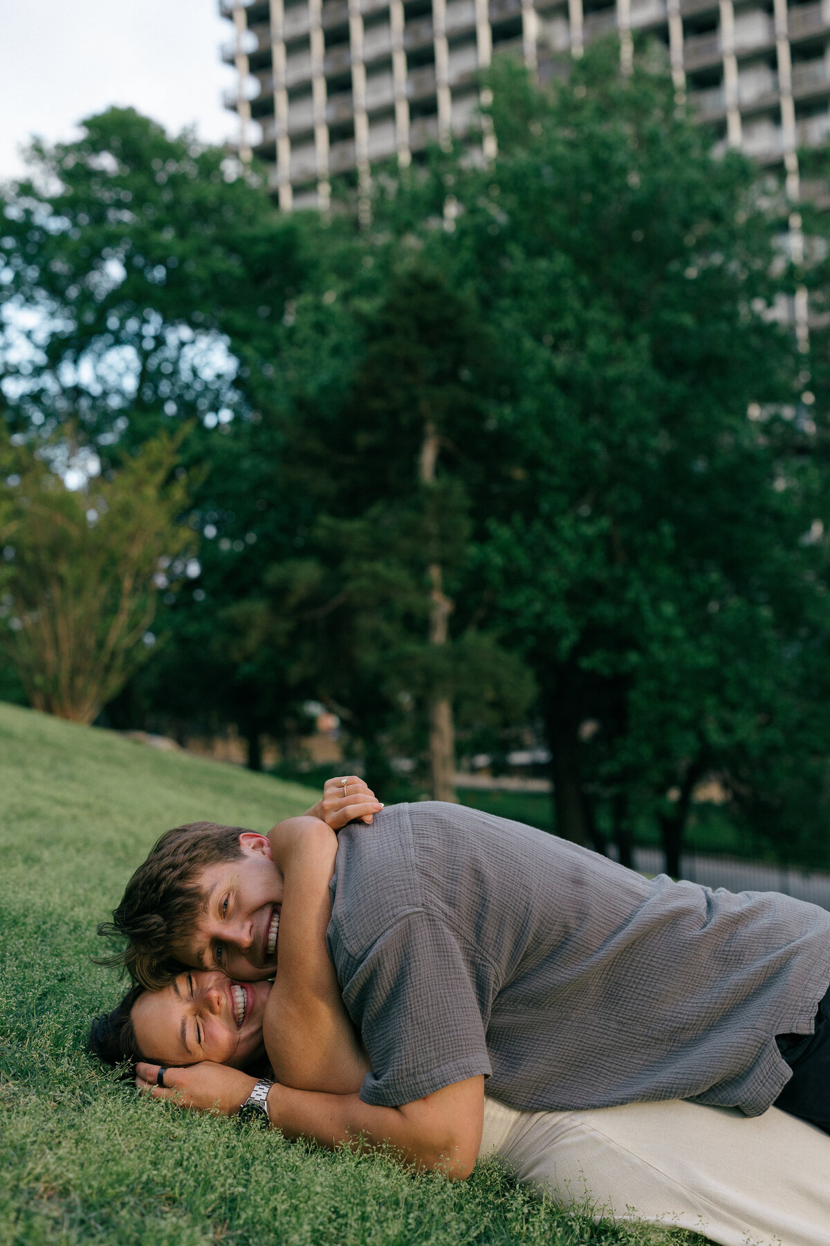 Playful Couple Snuggled on a Hillside – Bentonville Arkansas Engagement Photographer