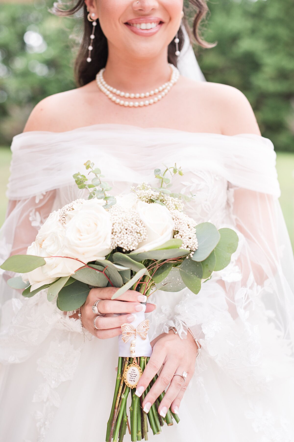 bride holding bouquet with special items