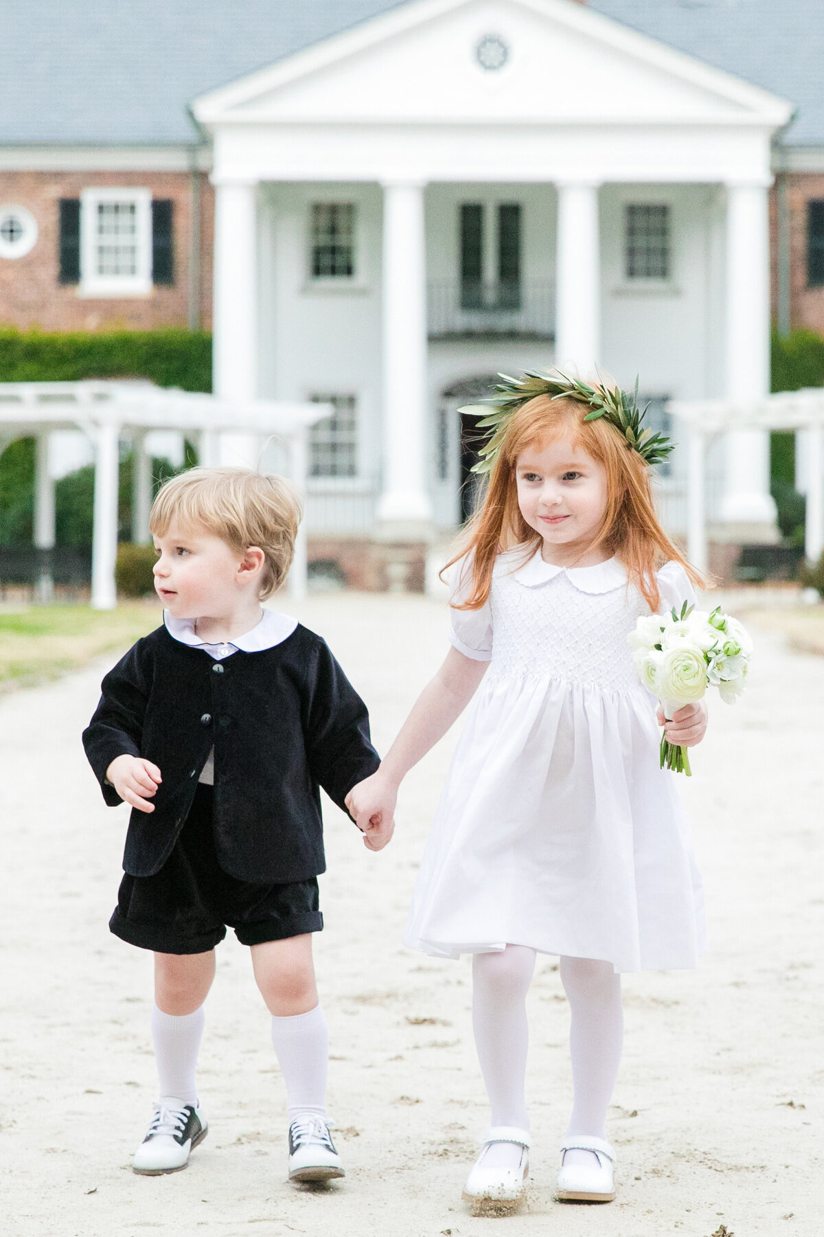 Flower girl and ring bearer walking down aisle at a wedding in Charleston, SC photographed by Dana Cubbage Weddings.
