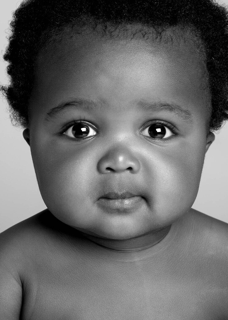 A black and white photo of a baby, capturing their innocent expression and soft features.