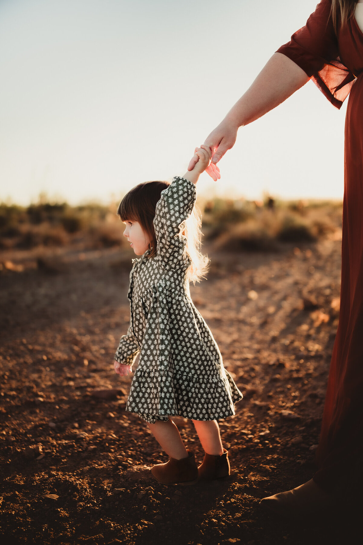 toddler in the desert holding moms hand