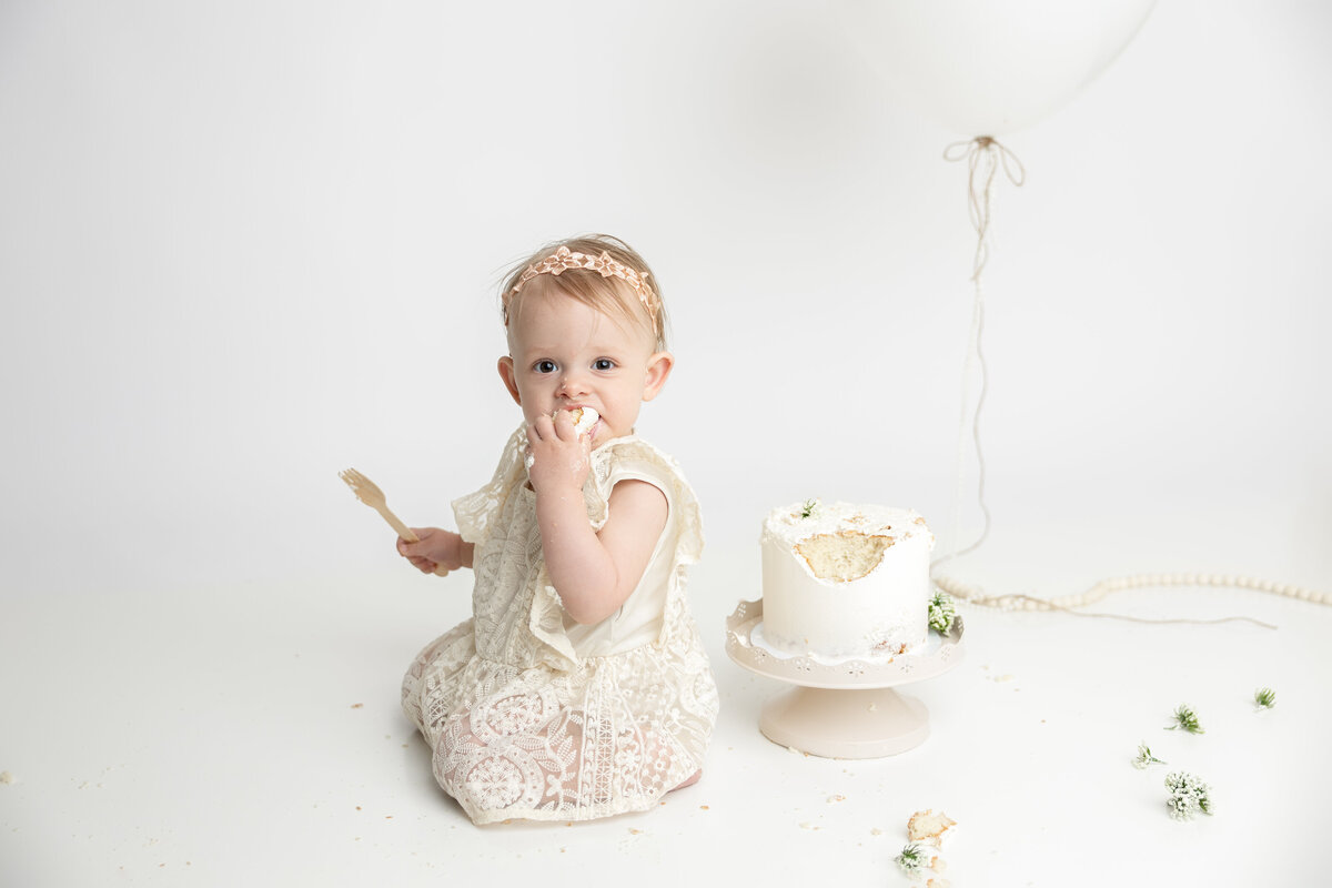 Minimalist cake smash with large white balloon and greenery