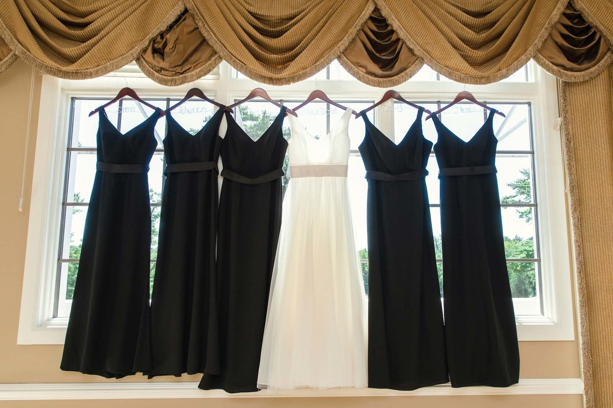 Bride and bridesmaids dresses hanging in window straight on at Stonebridge Country Club