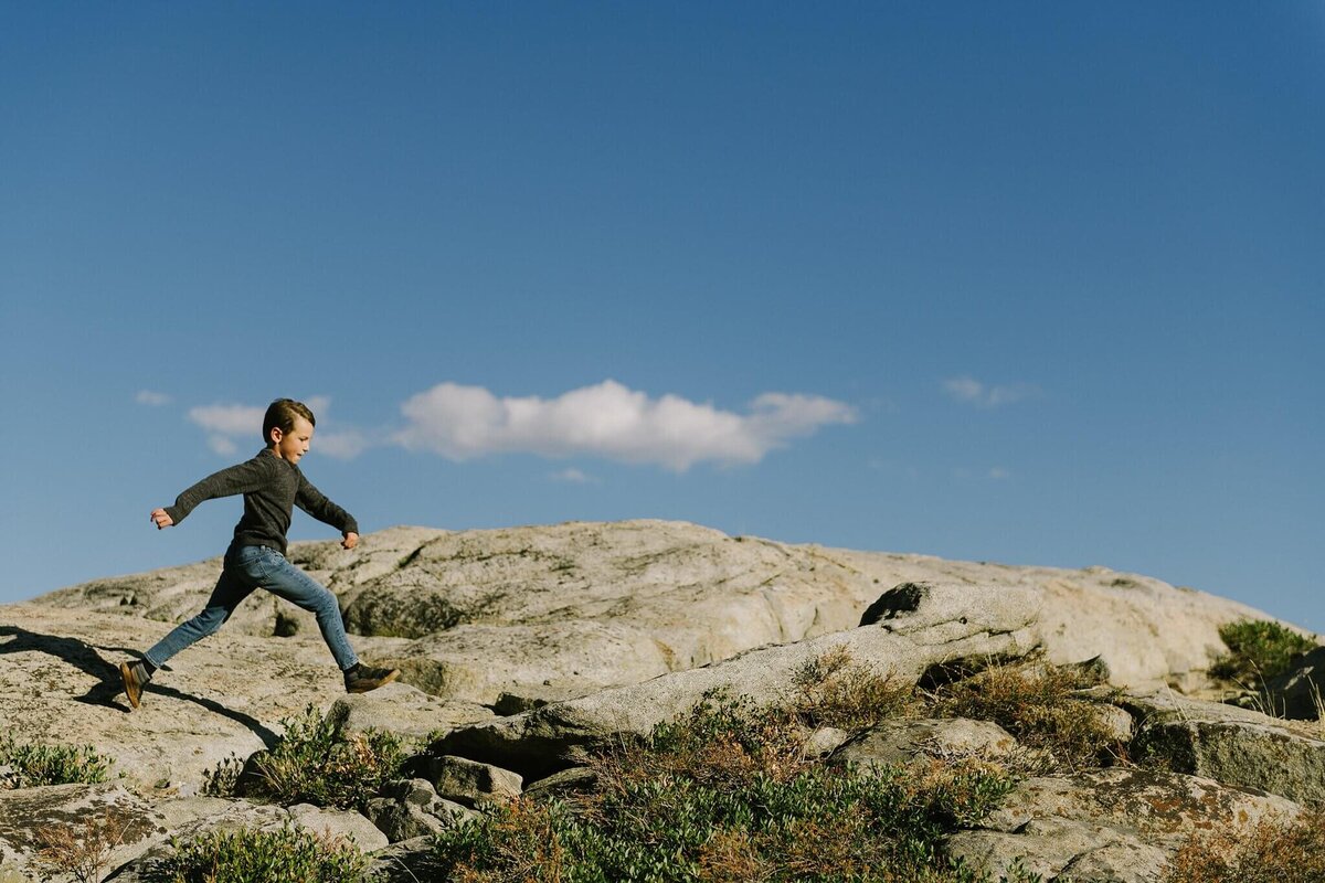 boy walking on granite rocks on donner summit during fall family portraits