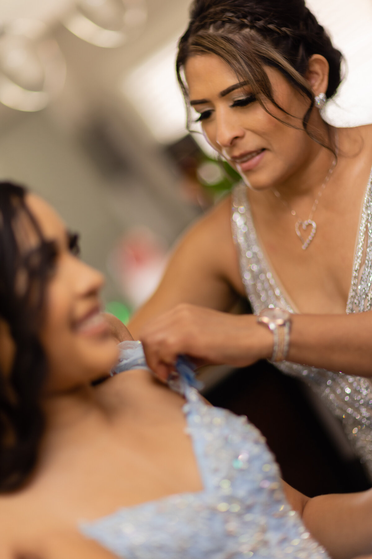 A heartfelt moment of Victoria's mom helping with the final touches on her quinceañera gown at their Cleveland home, showcasing love and family bonds on this special day.