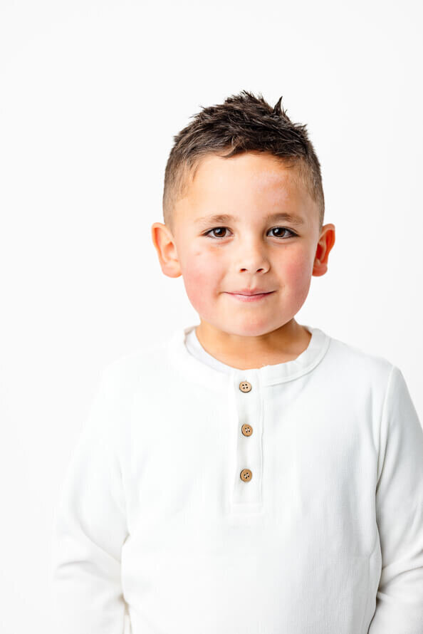 Boy look at camera with a small smile.