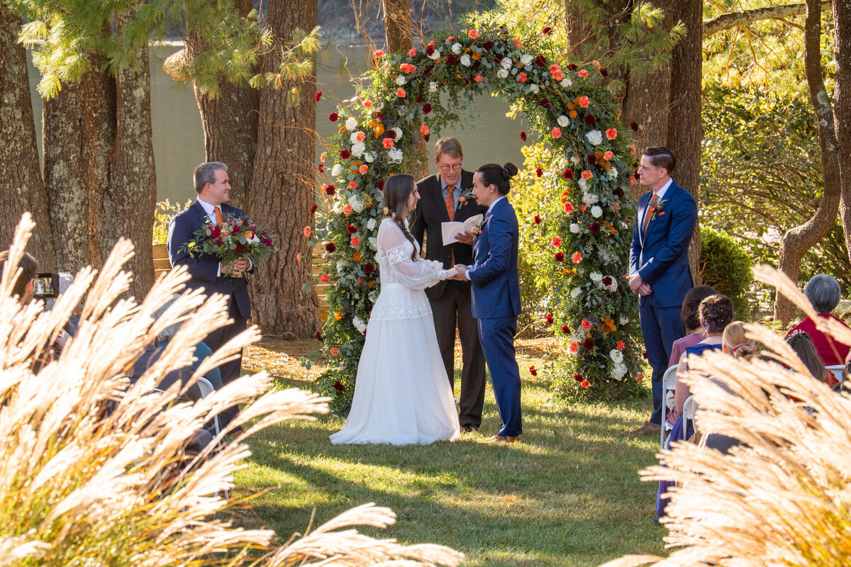 A couple holding hands as they say their vows at their wedding 