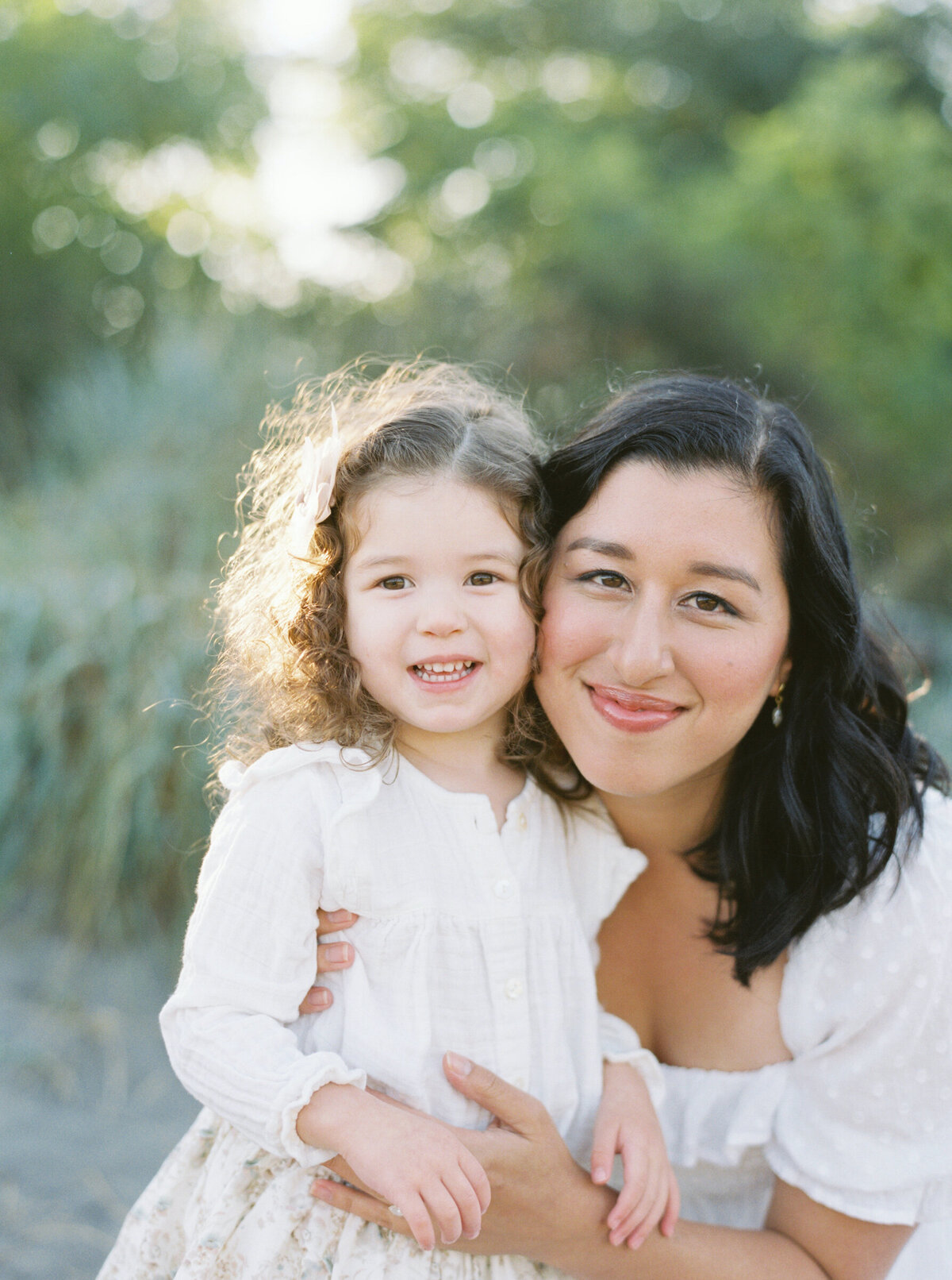 mother and daughter cheek to cheek for this film portrait on the beach 