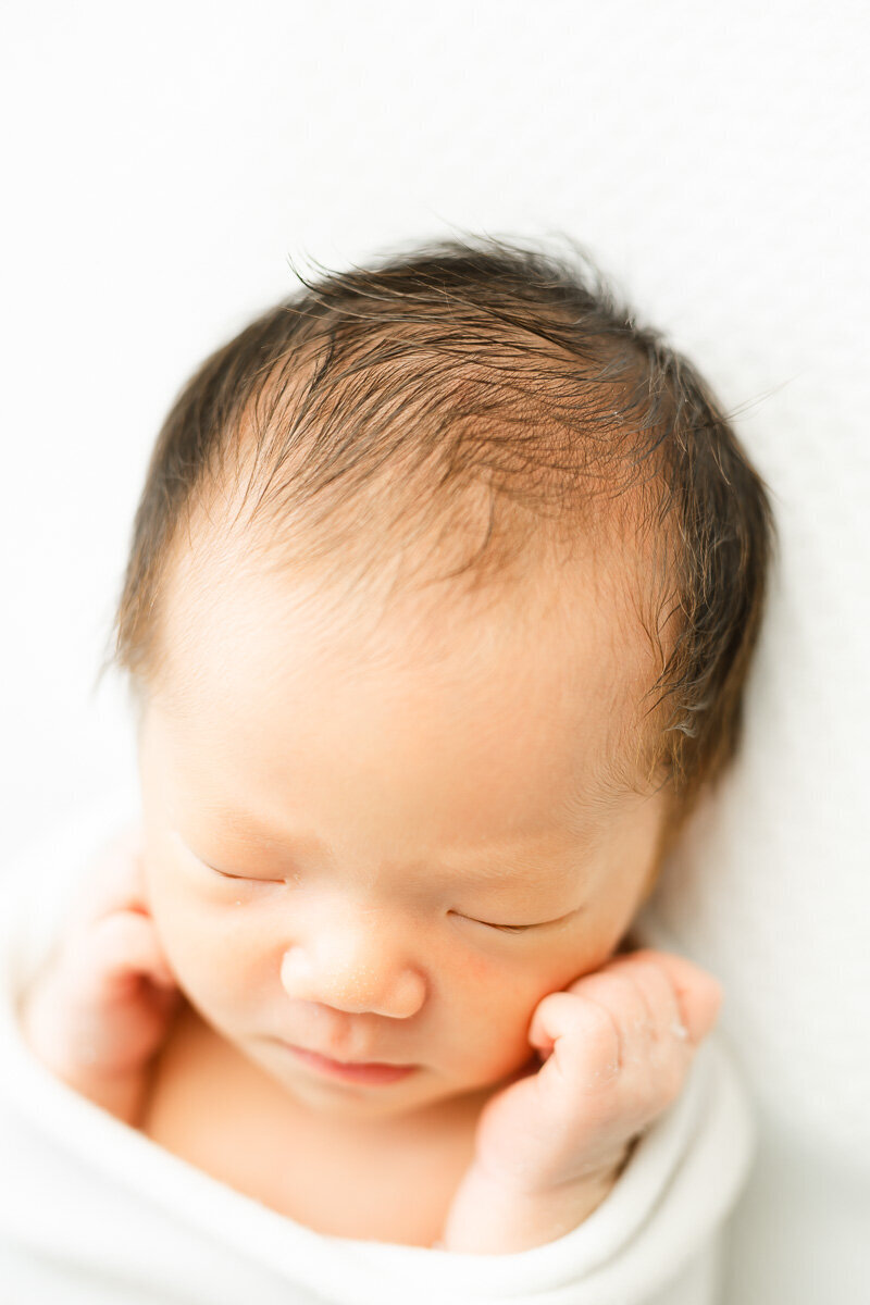 detailed shot of a newborn's black hair during a lifestyle infant photography session in Austin. 