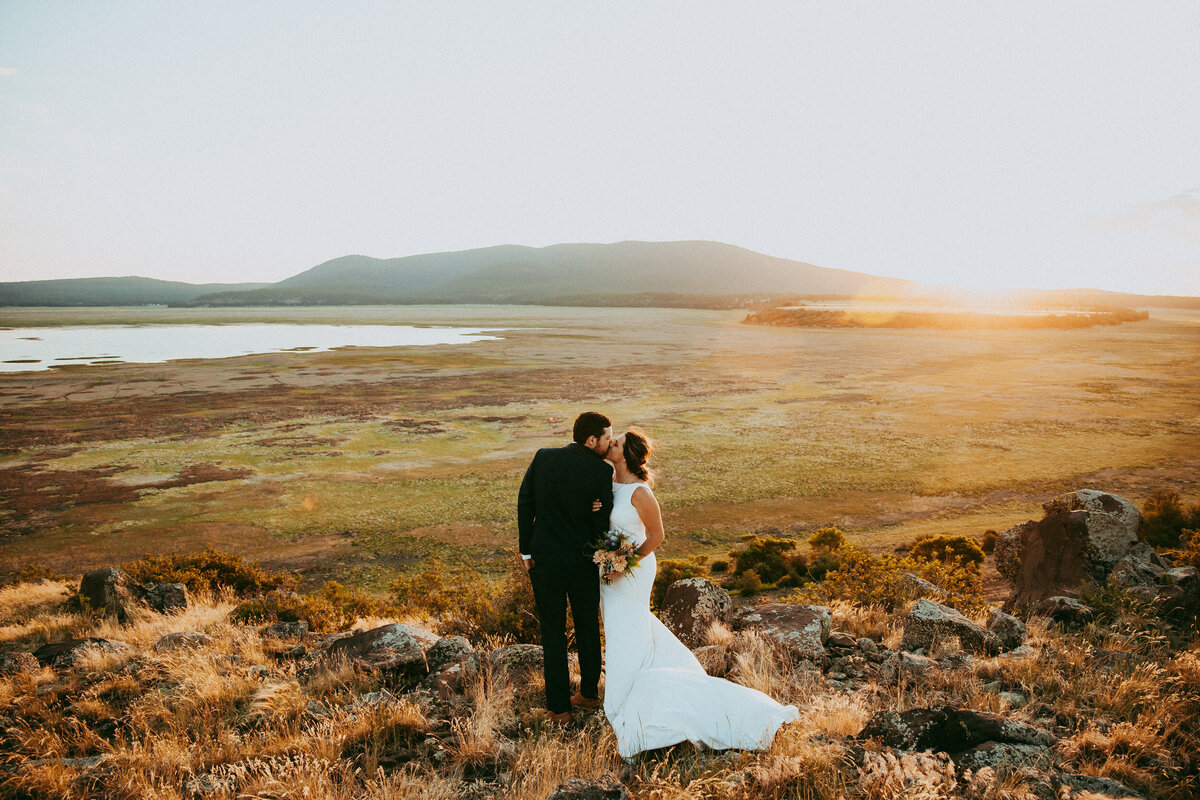 bride and groom take photos near mormon lake in flagstaff arizona