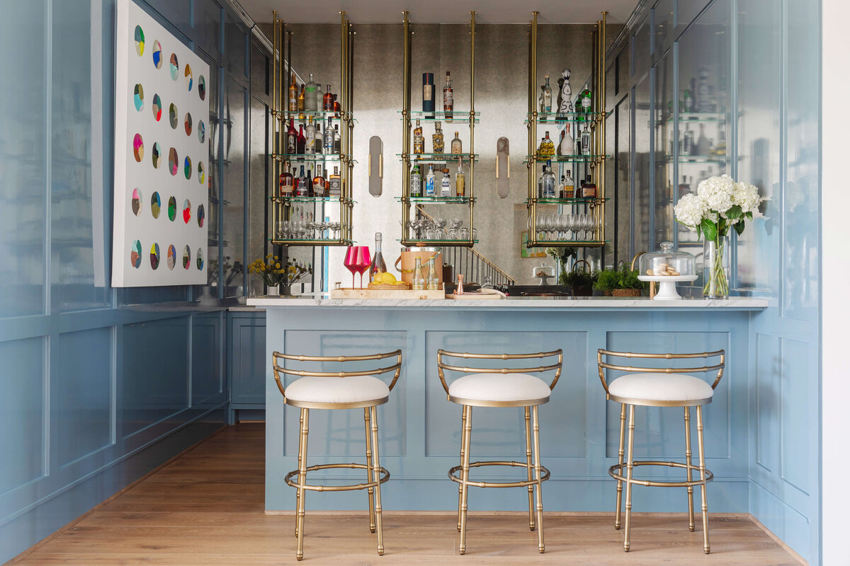 oyster creek studios memorial new build blue bar area with golden stools and modern painting