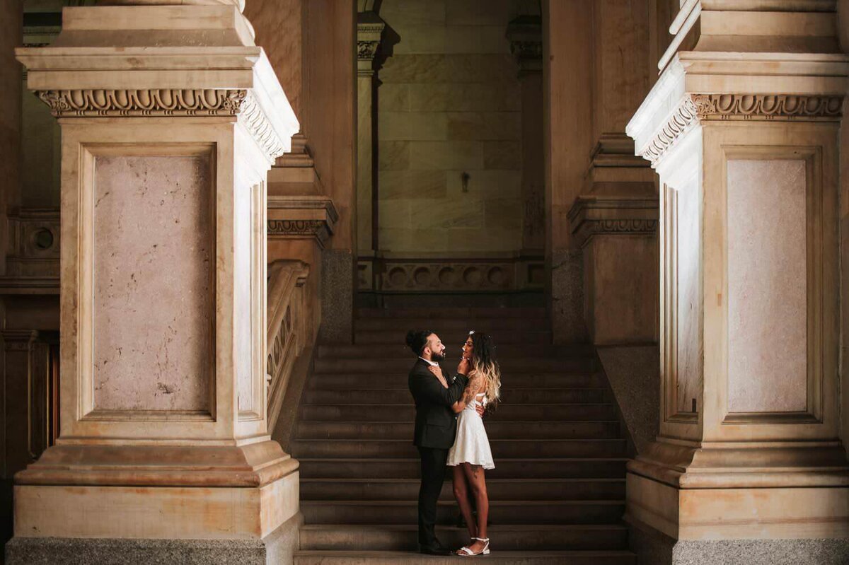 South Asian couple embracing each other and smiling on a staircase in Philadelphia.