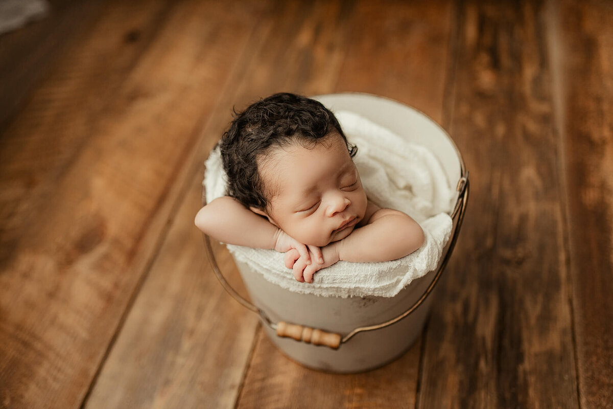 sleeping infant in white bucket