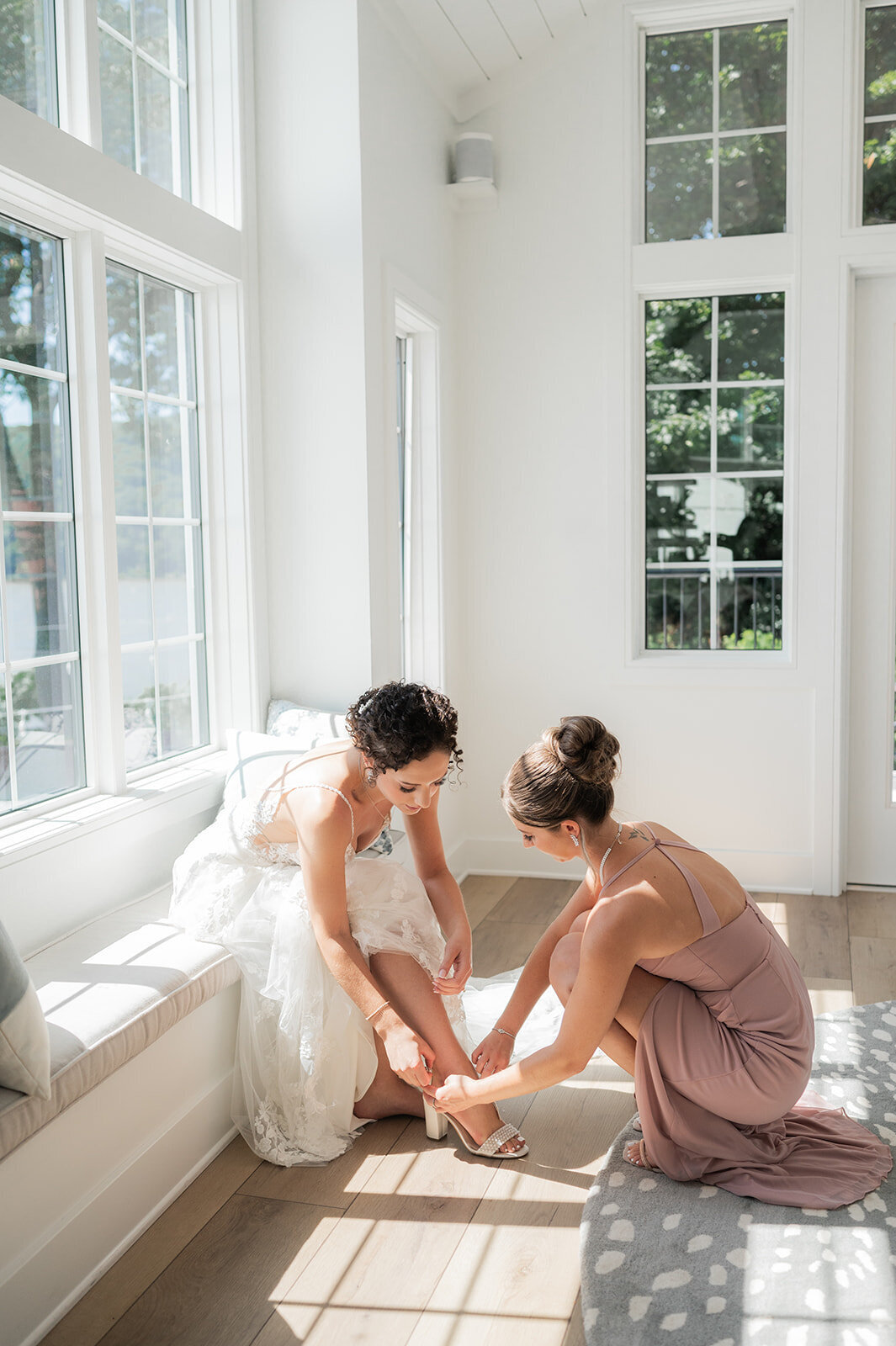 bridesmiad helps put on shoes during grandview wedding