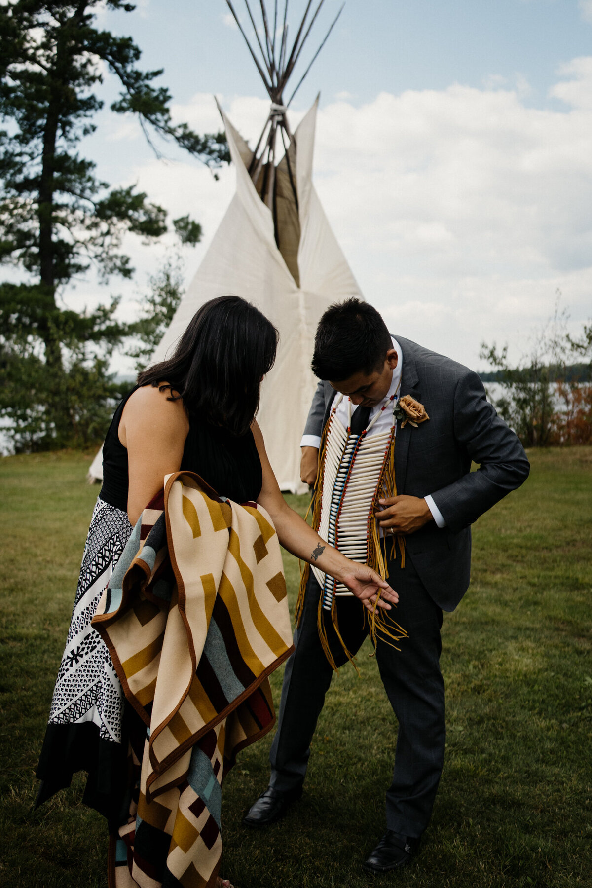couple standing in front of teepee tent