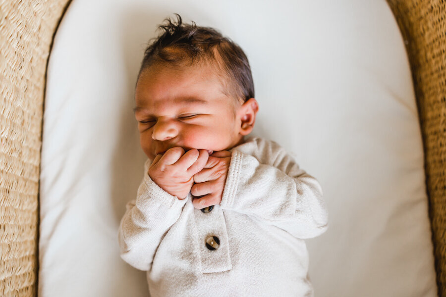 baby boy smiling in bassinet