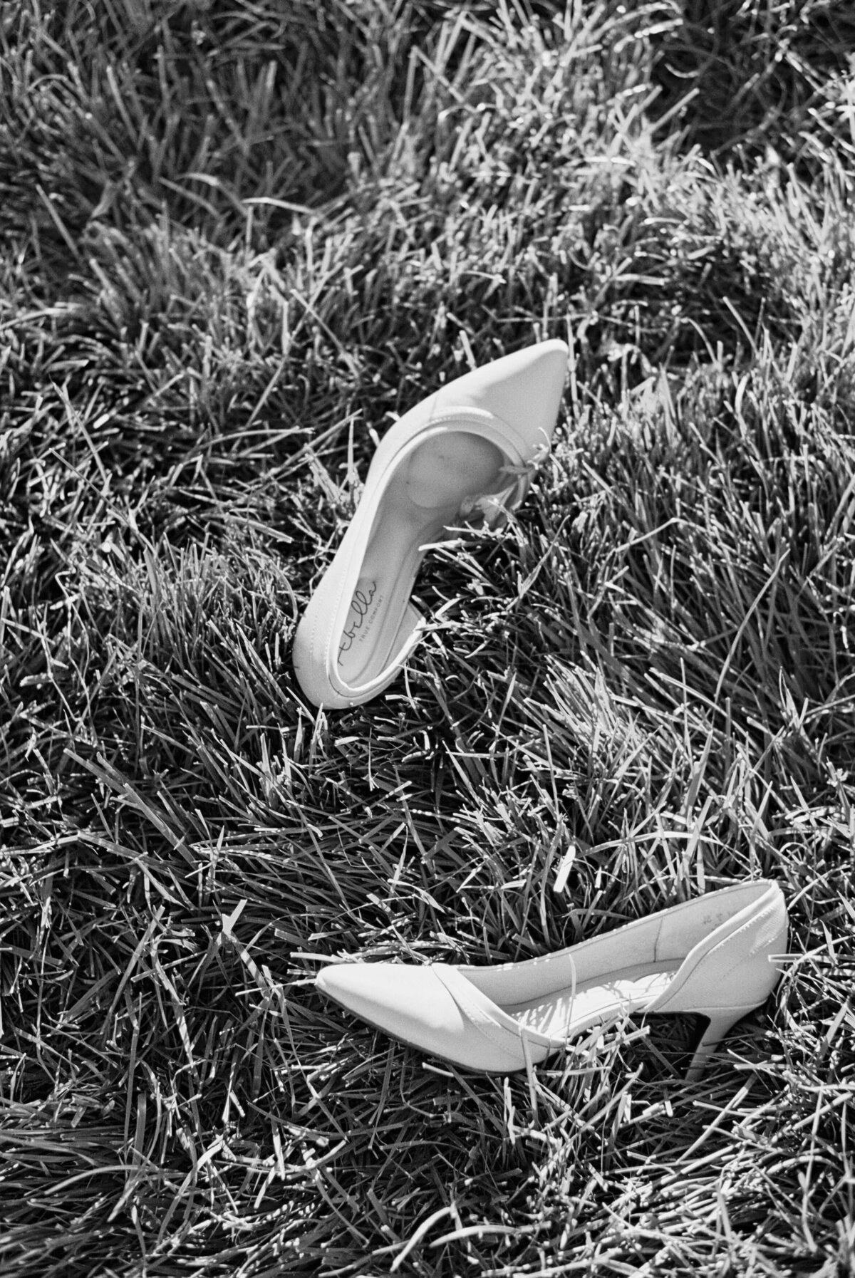 Black and white image of woman's heels laying in grass, Columbus session by Philadelphia photographer.