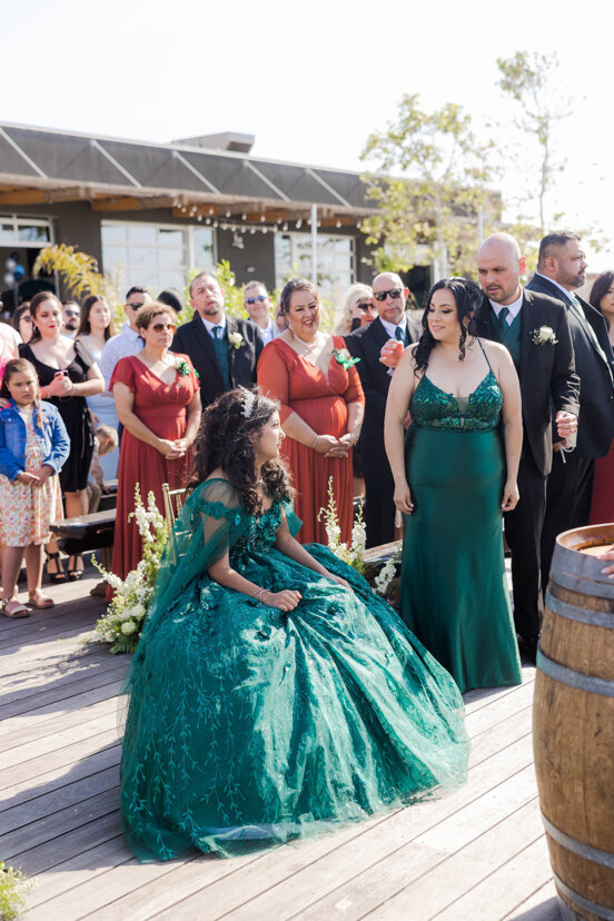 girl-sitting-mom-standing-quinceanera