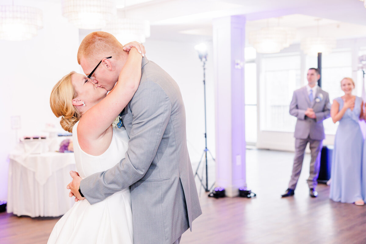 A bride and groom kissing during their first dance representing candid Cape Cod wedding photos