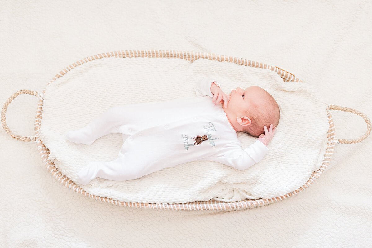 Calm newborn baby boy wrapped in blanket with natural light