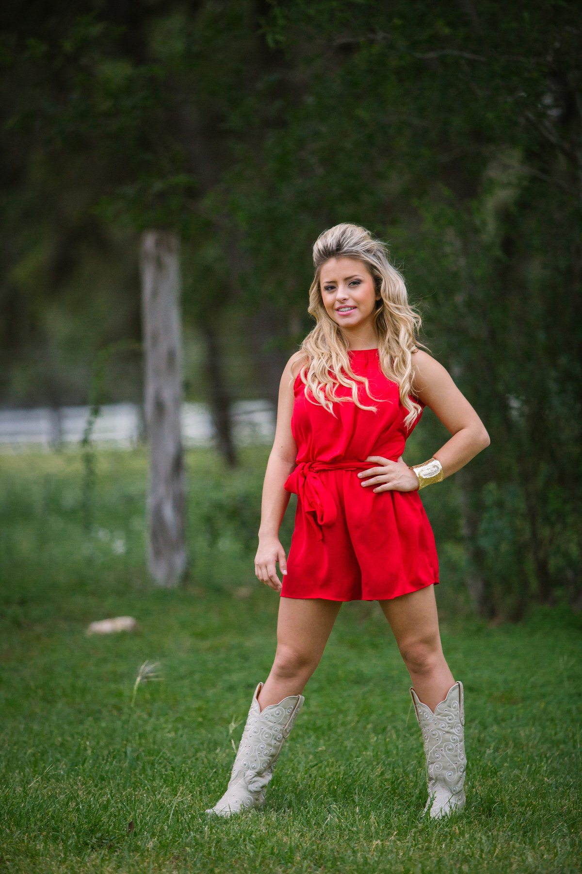 high school senior girl in red dress posing for San Antonio senior photographer