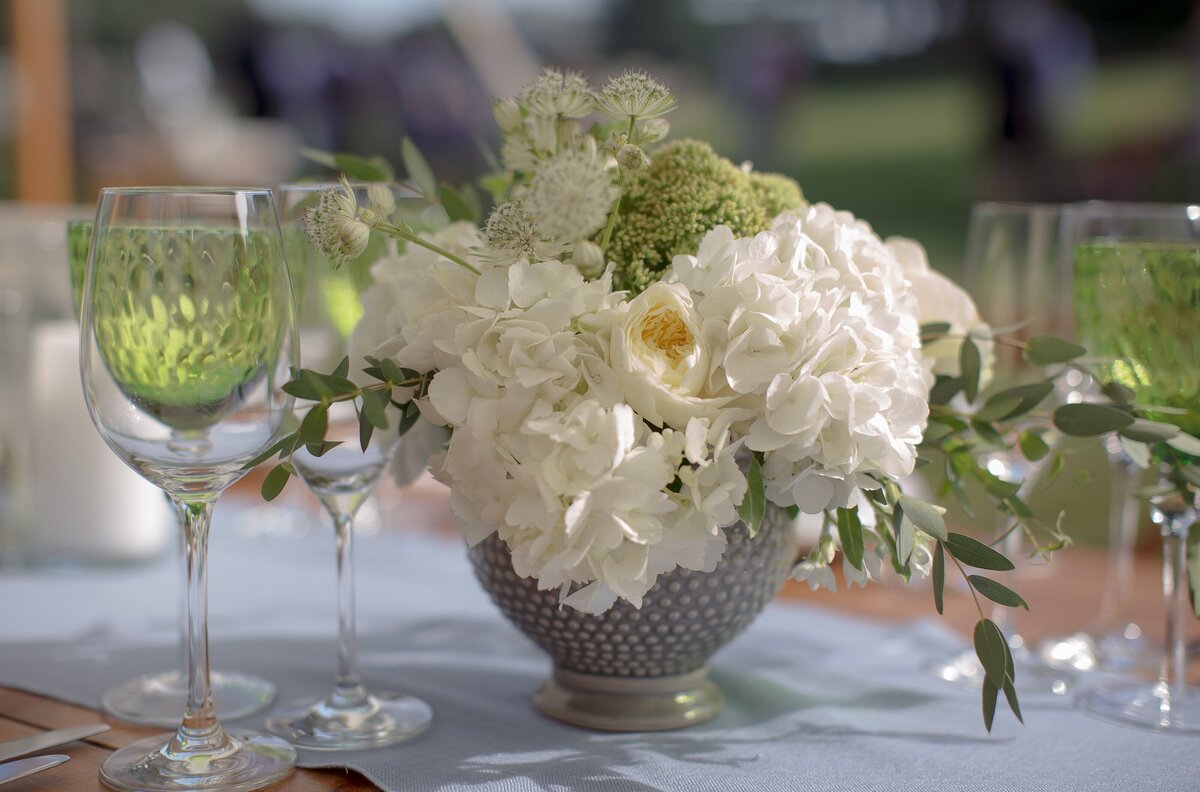 Cream and green tabletop decor during wedding reception.