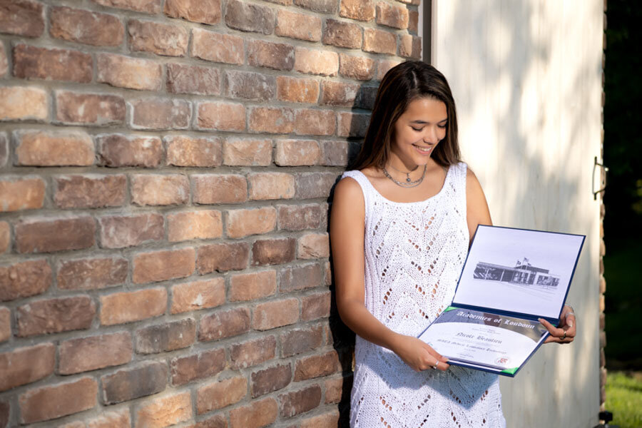 senior with diploma outdoors