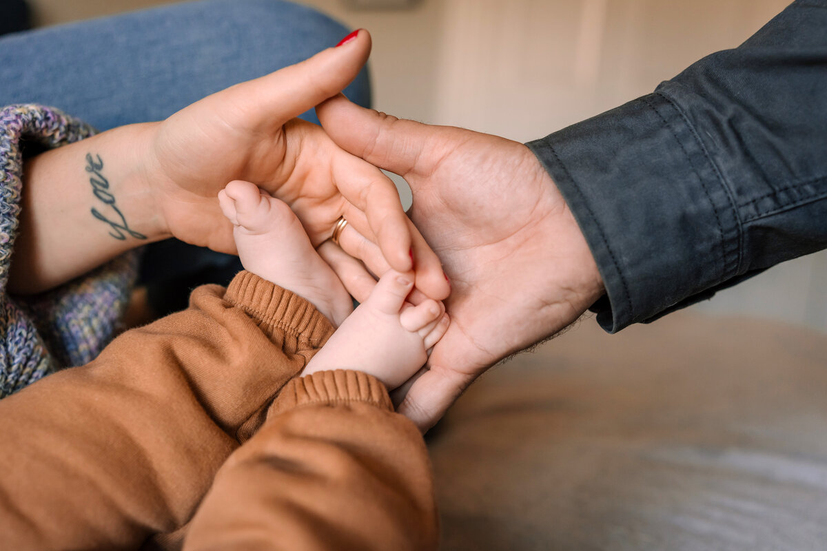 parents holding baby feet