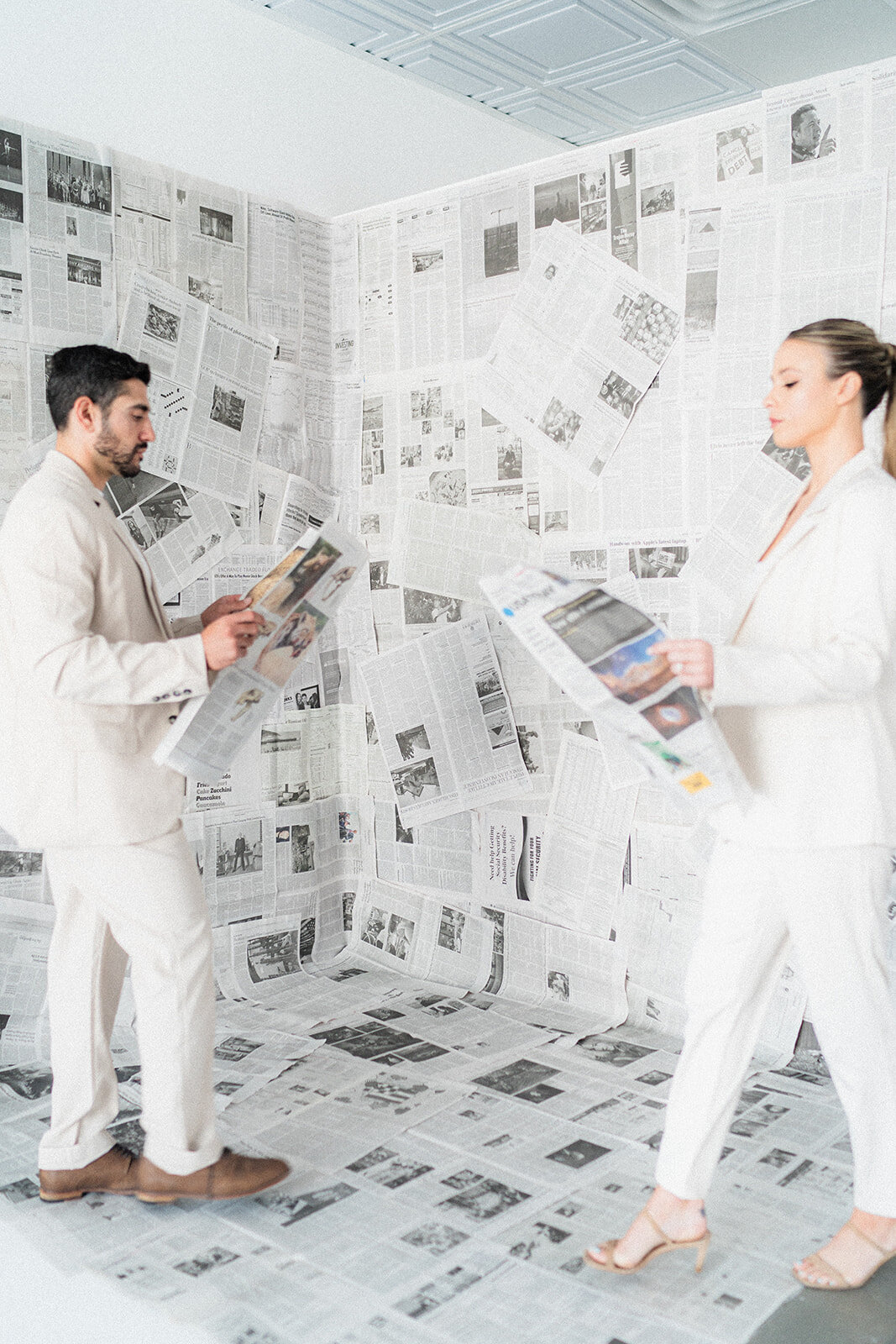 A couple walks with newspapers