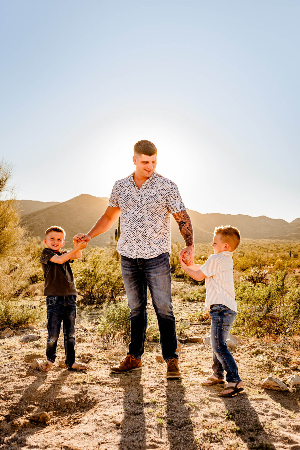dad and two sons playing in AZ desert for photographer Amber
