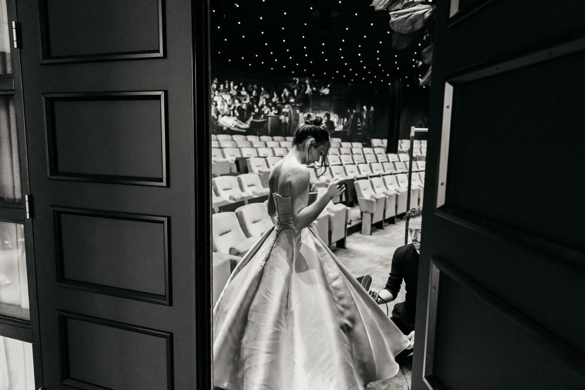 Actrice in gala jurk in een theaterzaal.