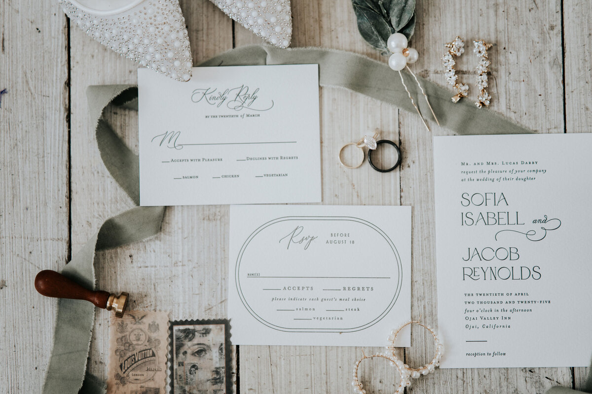 flat lay of details for the wedding day wedding invitation and ribbon and diamond shoes captured by Idaho Falls Wedding Photographer