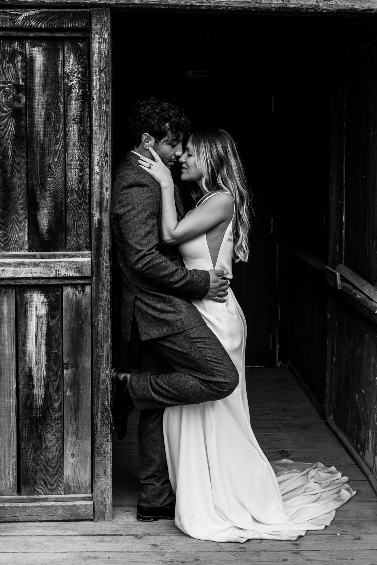 Candid elopement photo of the couple laughing by a crystal-clear lake.