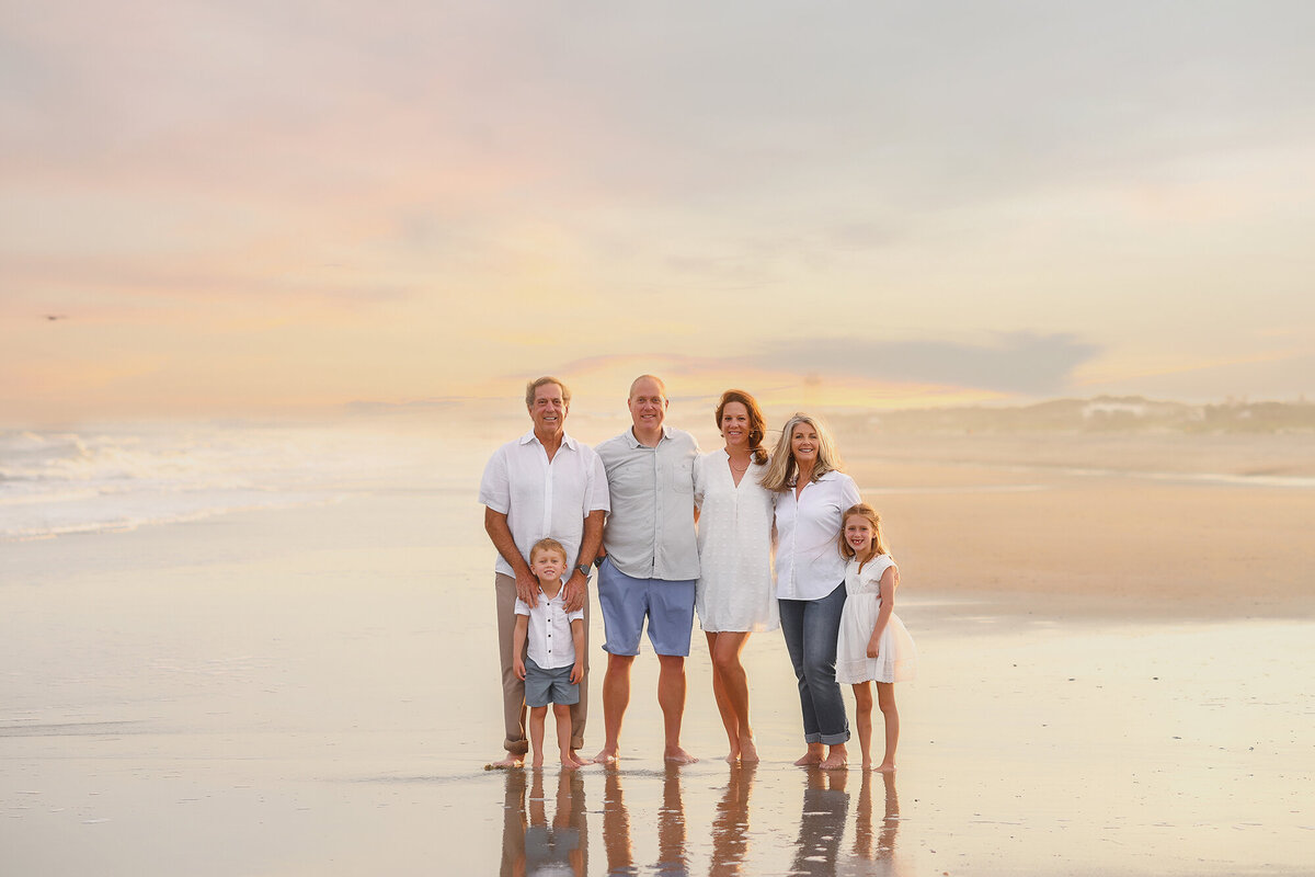 Family poses for Family Photos. on Isle of Palms beach in Charleston, SC.