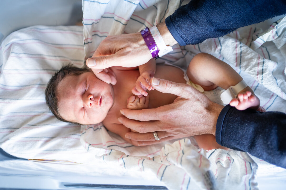 Dad comforting baby with his hands