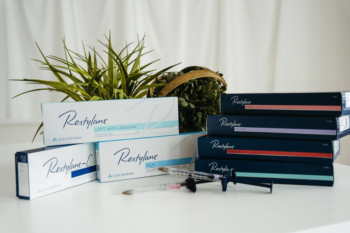 Stacked Restylane dermal filler boxes with syringe and greenery at Maxwell Aesthetics in Salem, Oregon