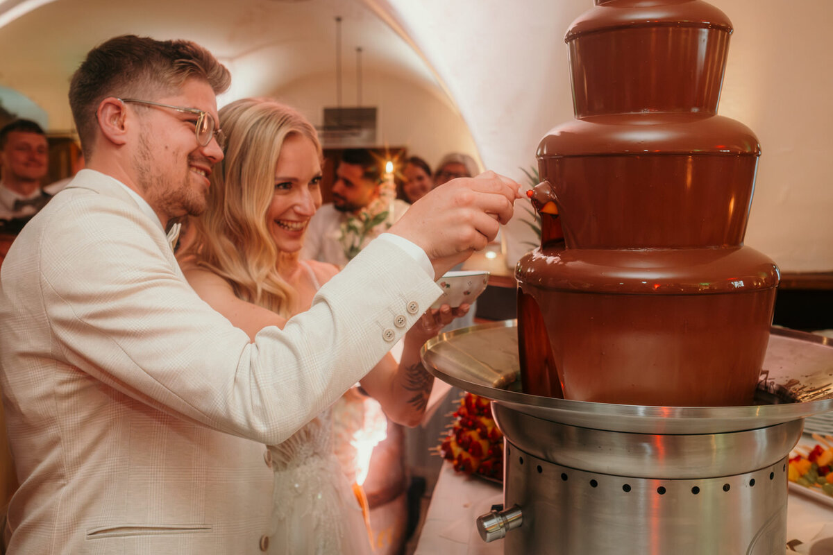 The wedding couple has a sweet moment at the chocolate fontain.